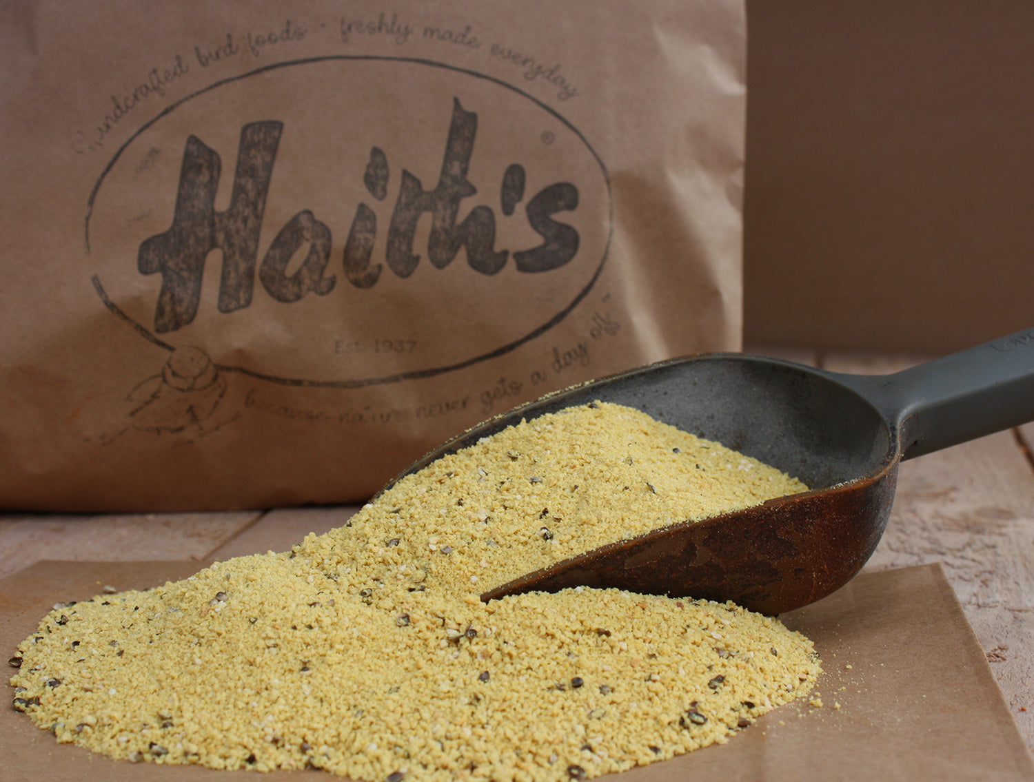 Haith's red factor ingredient inside a scoop consisting of a yellow colour, in front of a Haith's paper bag