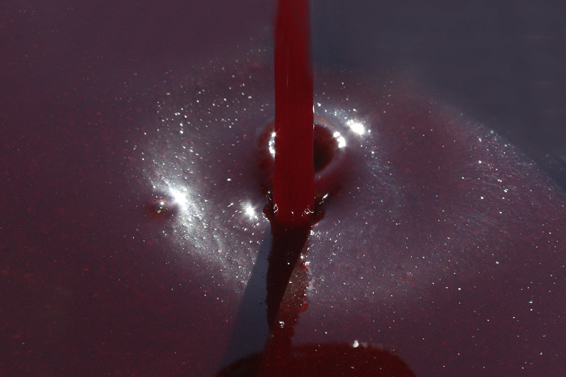 Haith's liquid robin red being poured into a bucket